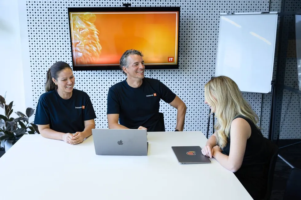 Team meeting in boardroom with orange screen