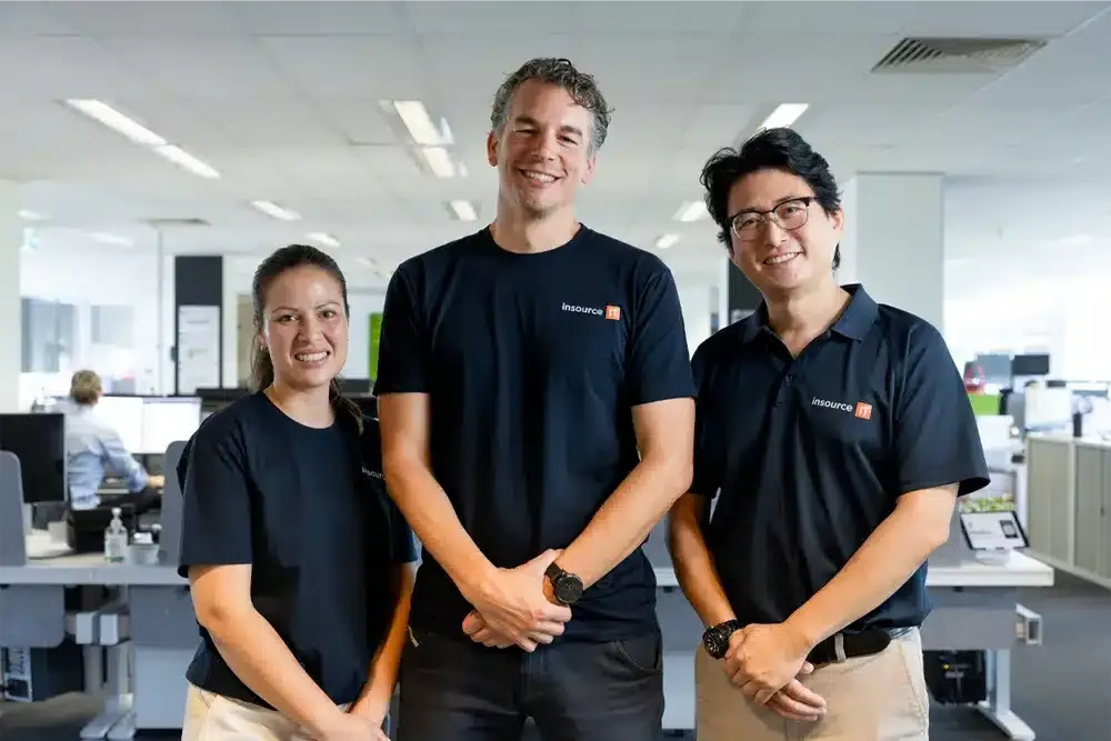 Three Insource IT team members standing together in the office
